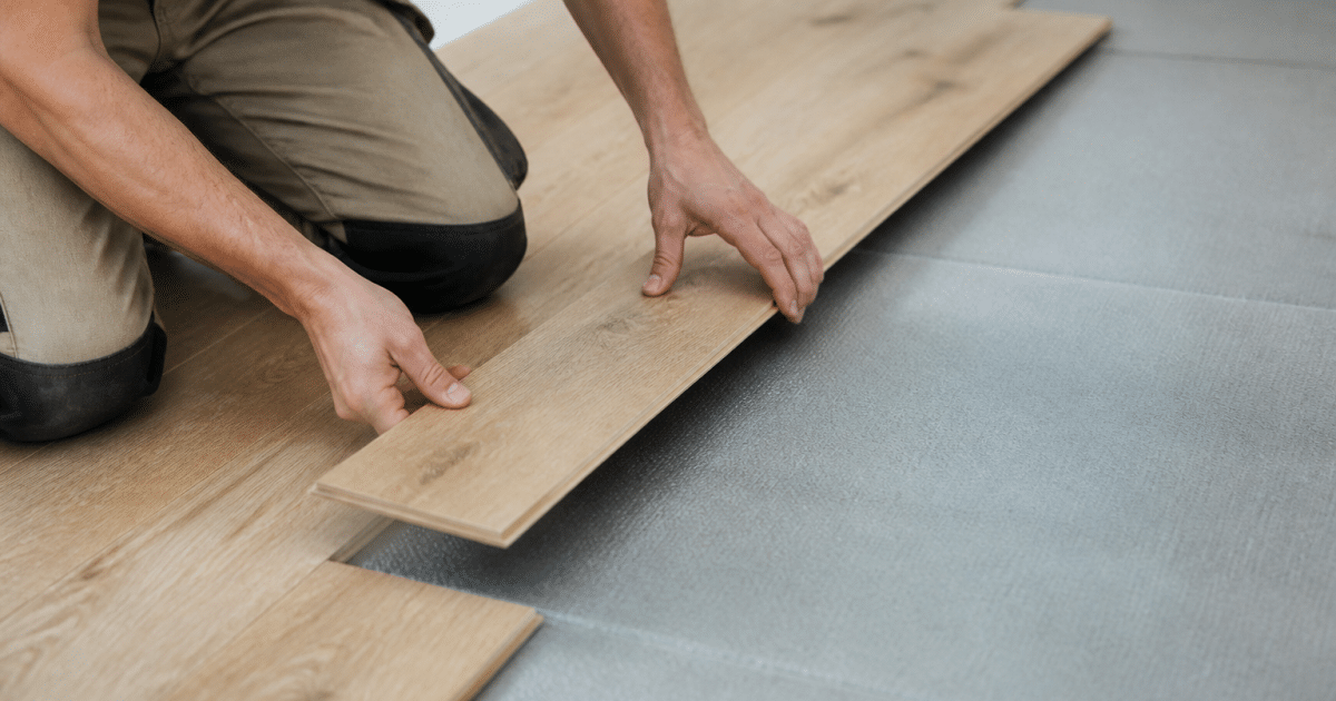 Mains posant des lames de bois sur sous-couche grise