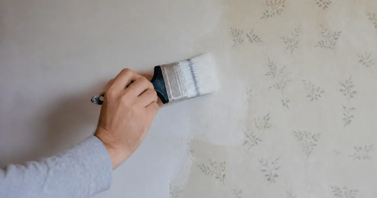 Pinceau appliquant peinture directement sur papier peint mural existant