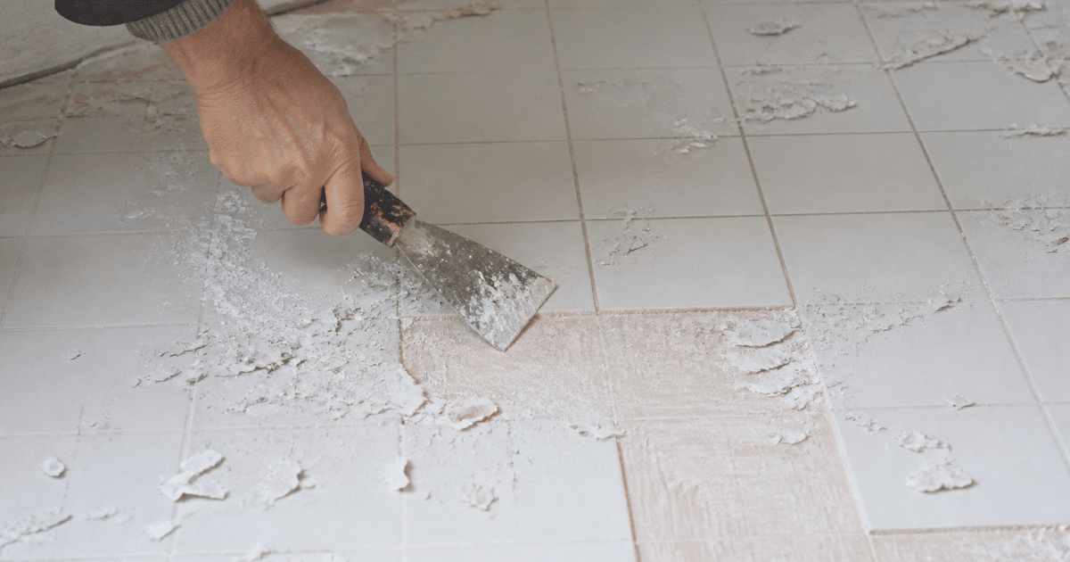 Racloir metallique enlevant couche peinture blanche carrelage sol