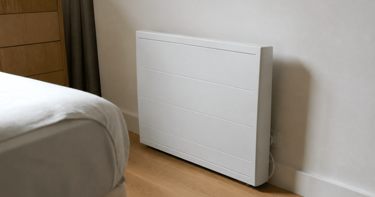 Radiateur électrique blanc posé contre mur chambre