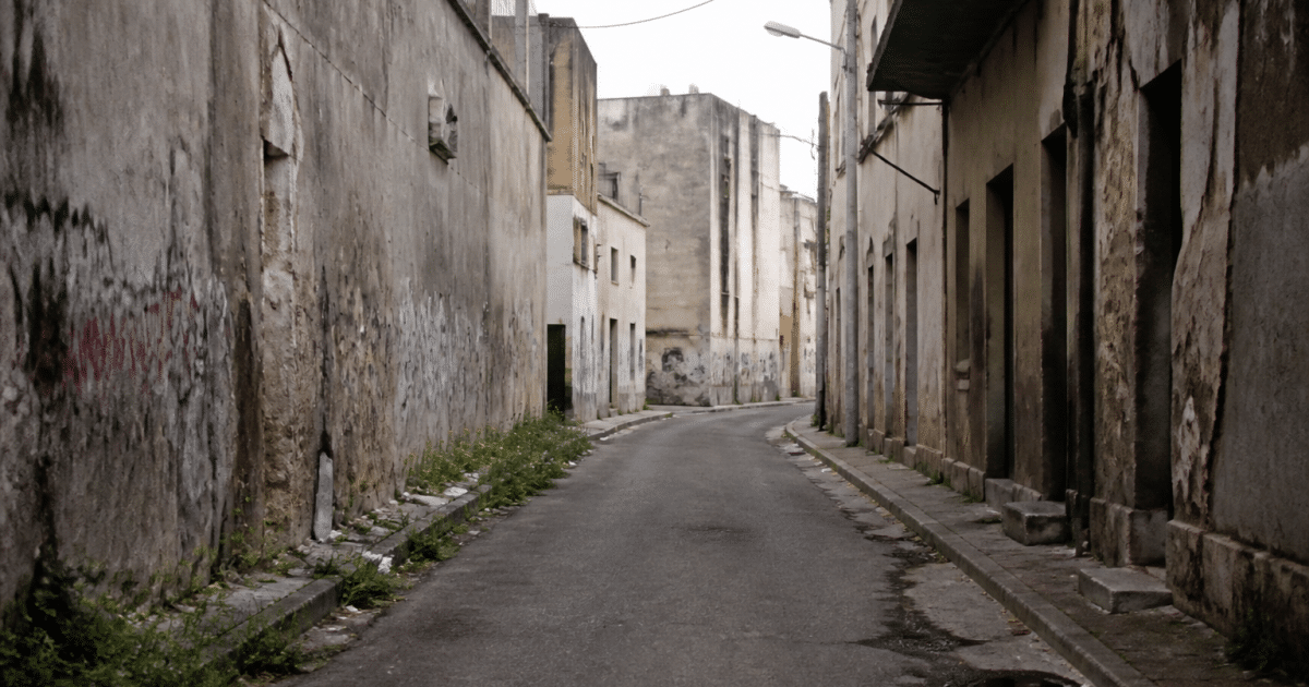 Rue déserte avec immeubles dégradés et graffitis visibles