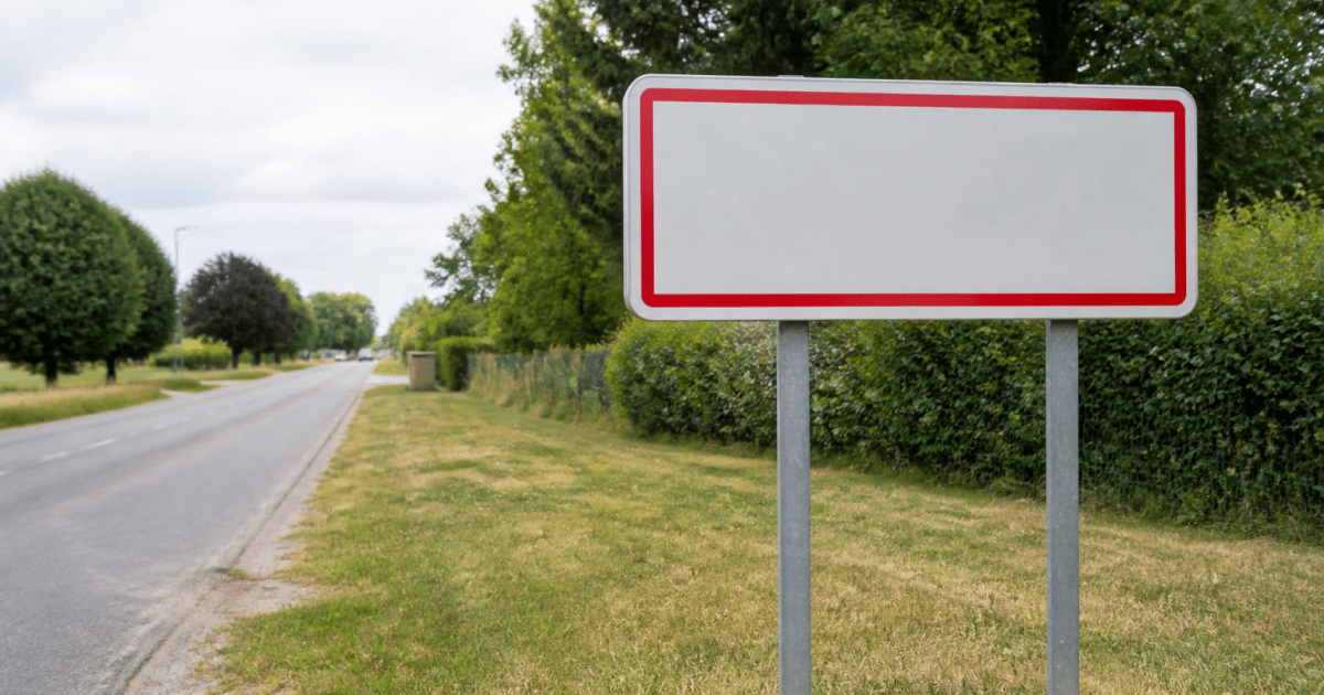 Panneau routier affichant le nom de la ville avec chiffres de population