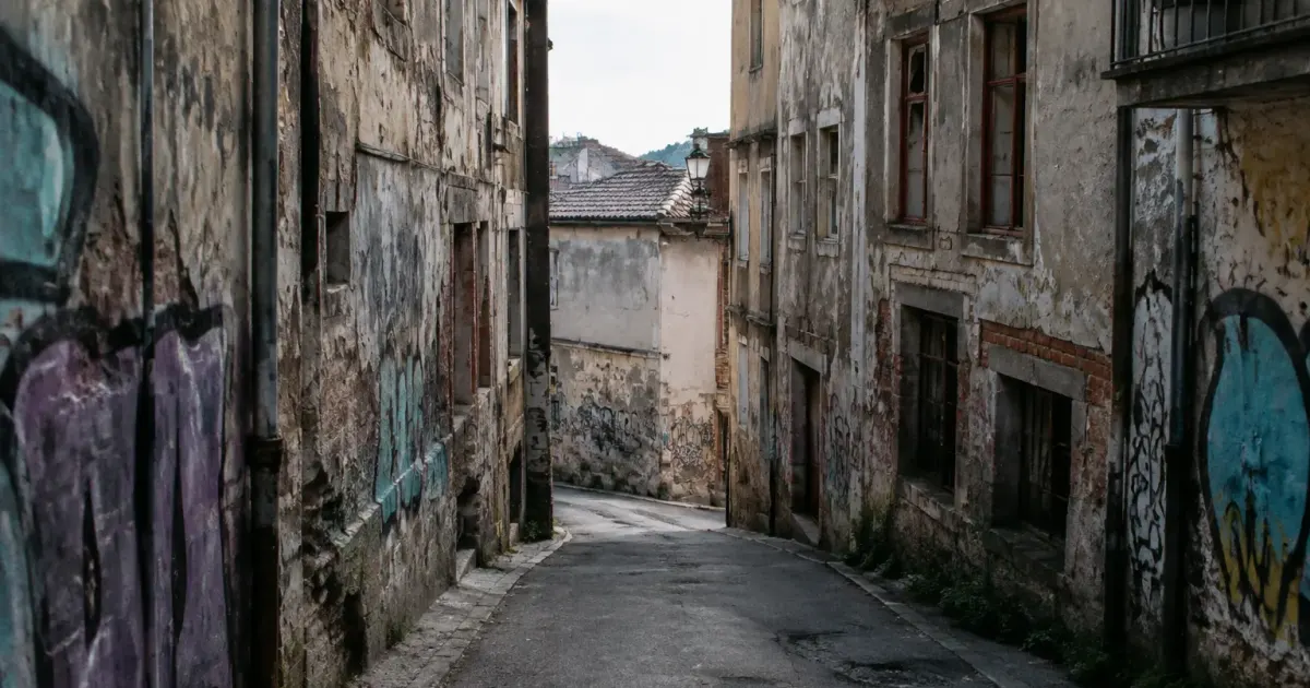 Ruelle vide surplombee par batiments delabres aux murs tagues