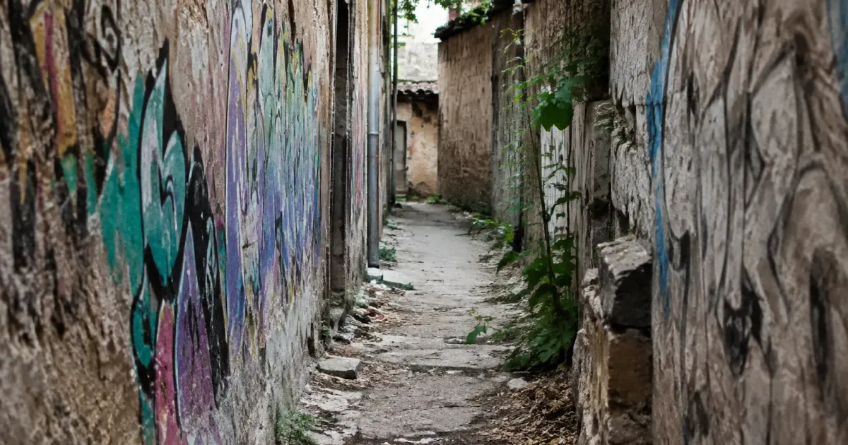 Ruelle etroite debris au sol murs graffitis